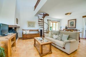 een woonkamer met een bank en een tv bij Ideal Property Mallorca - Ca na Tonina in Port de Pollença