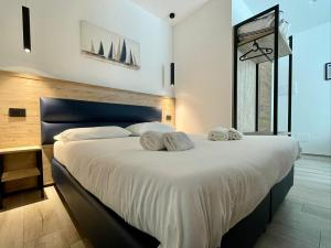 1 dormitorio con 1 cama blanca grande y toallas. en Bari Airport Rooms en Bari