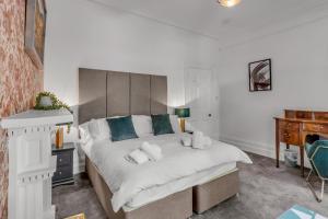 um quarto com uma grande cama branca com almofadas azuis em Boardman Lodge, City centre, Park view, Games - Ginger & Gold ltd em Norwich