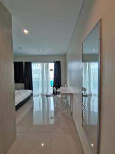 a white room with a bed and a table and a mirror at Peaceful 1-bedroom unit at Marina Island by JoMy Homestay in Lumut +46 photos