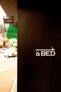 a sign on the side of a building with the word bed at CASA Kamakura Espresso&BED in Kamakura