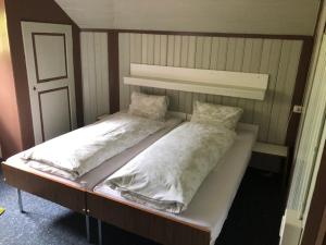 a bed with two pillows on top of it at Hotel Bären Lodge in Kiental