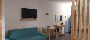 ein Wohnzimmer mit einem Sofa und einem TV an der Wand in der Unterkunft Galanthus in Aosta