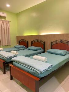 3 posti letto in una stanza con pareti verdi di 3 Single Bed with Private Bathroom a Kuala Perlis