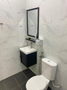 bagno con servizi igienici, lavandino e specchio di 3 Single Bed with Private Bathroom a Kuala Perlis