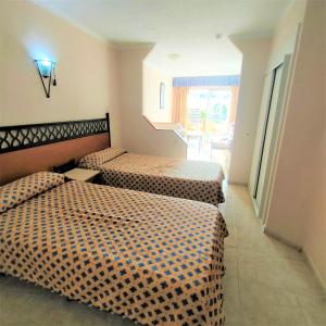 a hotel room with two beds and a window at Sunny Studio In Santa Maria Aparthotel in Adeje