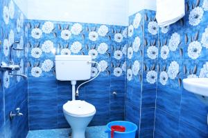 a blue tiled bathroom with a toilet and a sink at HOTEL DREAM PALACE in Puri