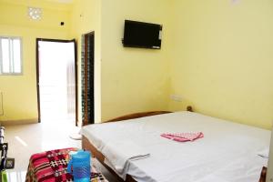 a bedroom with a bed and a tv on the wall at HOTEL DREAM PALACE in Puri