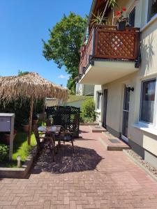 un patio con tavolo e sedie e un balcone. di Brandt Ferienwohnungen Jägersberg a Ahlbeck