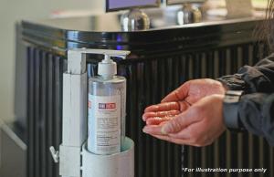 a person is washing their hands next to a machine at Hotel Unicontinental in Mumbai