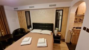 een kamer met een groot bed en 2 witte handdoeken. bij Cozy house with nice garden in heart of city center in Cluj-Napoca