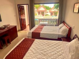 two beds in a bedroom with a view of a balcony at Hong Bin Bungalow in Phu Quoc +103 photos