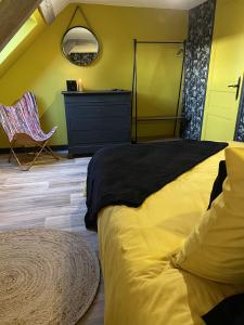 a bedroom with a bed and a dresser and a chair at Gîte cosy La Joconde in Isbergues