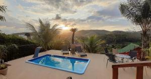 a swimming pool sitting on top of a patio at Suítes Sunset in Miguel Pereira