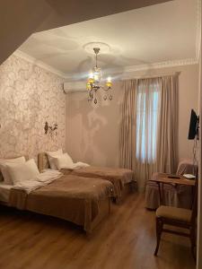 a bedroom with two beds and a chandelier at Apartment Botanikuri 15 in Tbilisi City