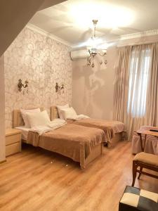 a bedroom with two beds and a chandelier at Apartment Botanikuri 15 in Tbilisi City