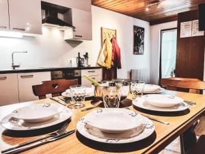 a kitchen with a wooden table with plates and glasses at Casa Gomes in Gaschurn