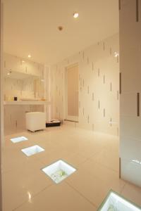 um quarto amplo com paredes brancas e pisos brancos em 旭川ホテルリップローズ-大人専用 em Asahikawa