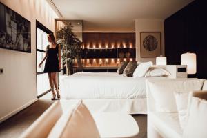 a woman standing next to a bed in a room at Bdesign & Spa in Paradou