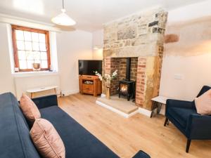 a living room with a couch and a fireplace at 3 Mill Wynd in Darlington