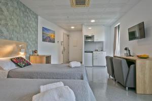a hotel room with two beds and a kitchen at Les Begues Apartments in Begues