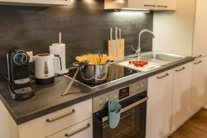 cocina con fregadero y fogones horno superior en APSTAY Serviced Apartments - Self Check-in en Graz