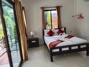 a bedroom with a bed with a white bow on it at Palm Tian Home A7 in Ban Chong Phli