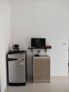 a kitchen with a small refrigerator and a television at Palm Tian Home A7 in Ban Chong Phli