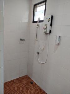 La salle de bains est pourvue d'une douche et d'une fenêtre. dans l'établissement Palm Tian Home A7, à Ban Chong Phli