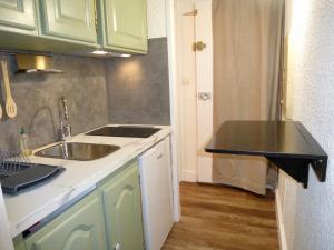 a kitchen with green cabinets and a sink at Boost Your Immo Néouvielle Barèges PM19 in Barèges