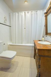 アビラにあるApartamentos turisticos Avila Villa Carmen Iのバスルーム(トイレ、洗面台、バスタブ付)