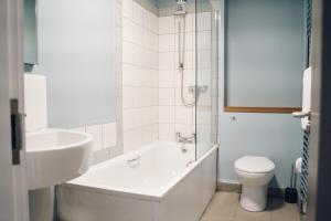 ein Badezimmer mit einer Badewanne, einem WC und einem Waschbecken in der Unterkunft Llety Arall in Caernarfon