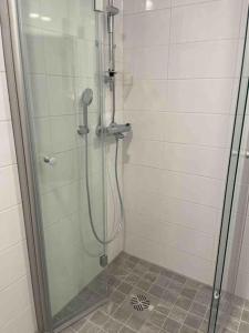 La salle de bains est pourvue d'une douche avec une porte en verre. dans l'établissement Family city apartment Helsinki, à Helsinki