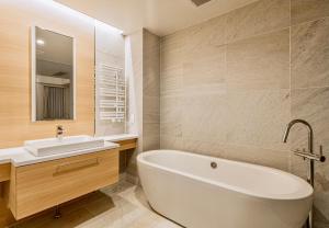 a bathroom with a white tub and a sink at Grand Phenix Hakuba by Jade Villa in Hakuba