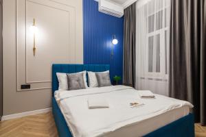 リヴィウにあるLEOGRAND Apartments on Svobody Avenue 43の青い壁のドミトリールームのベッド1台分です。