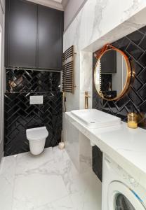 a bathroom with a sink and a toilet and a mirror at LEOGRAND Apartments on Svobody Avenue 43 in Lviv