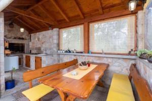a dining room with a wooden table and benches at Apartments Ivana in Orebić