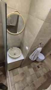 een badkamer met een wastafel, een spiegel en een toilet bij Lumen 1-bedroom apartment in the heart of Trikala in Tríkala