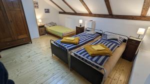 two twin beds in a room with wooden floors at Chajdaloupka 