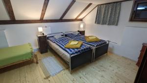 ein Schlafzimmer mit einem Bett mit zwei gelben Kissen darauf in der Unterkunft Chajdaloupka 