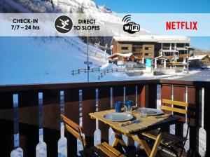 a table on a balcony with a snow covered mountain at Nice & cozy apartment facing the gondola - LA BOULE DE NEIGE 112 in Les Contamines-Montjoie