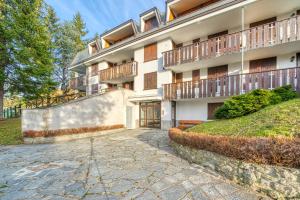 an apartment building with a walkway in front of it at Elegante appartamento-100mt dal centro-50mt dalla seggiovia-wifi-parcheggio gratuito in Sauze dʼOulx