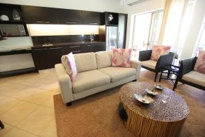 sala de estar con sofá y mesa en Moana Sands Beachfront Villas en Rarotonga