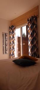 a bedroom with a large bed with a window at Mont Bivouac, chambre,entrée et Sdb privée,balcon vue MtBlanc in Passy