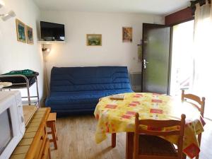 uma sala de estar com um sofá azul e uma mesa em Boost Your Immo Marmottes Barèges PM24 em Barèges