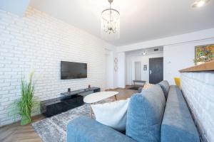 Brick Flats في أوراديا: غرفة معيشة مع أريكة زرقاء وجدار من الطوب الأبيض