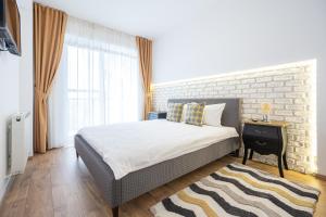 a bedroom with a bed and a brick wall at Brick Flats in Oradea