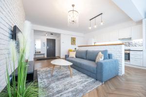 Brick Flats في أوراديا: غرفة معيشة مع أريكة زرقاء وطاولة
