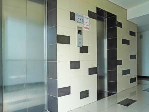 un ascensore in un edificio con parete piastrellata di OYO 90391 Gkitroom a Karawang