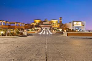 een groot gebouw met 's nachts een verlichte binnenplaats bij The Cascades Golf Resort, Spa & Thalasso in Hurghada